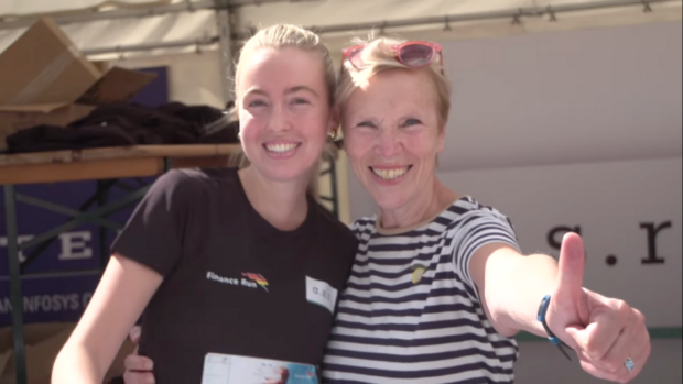 Twee vrouwen op de finance run die blij kijken. Een steekt een duim op.